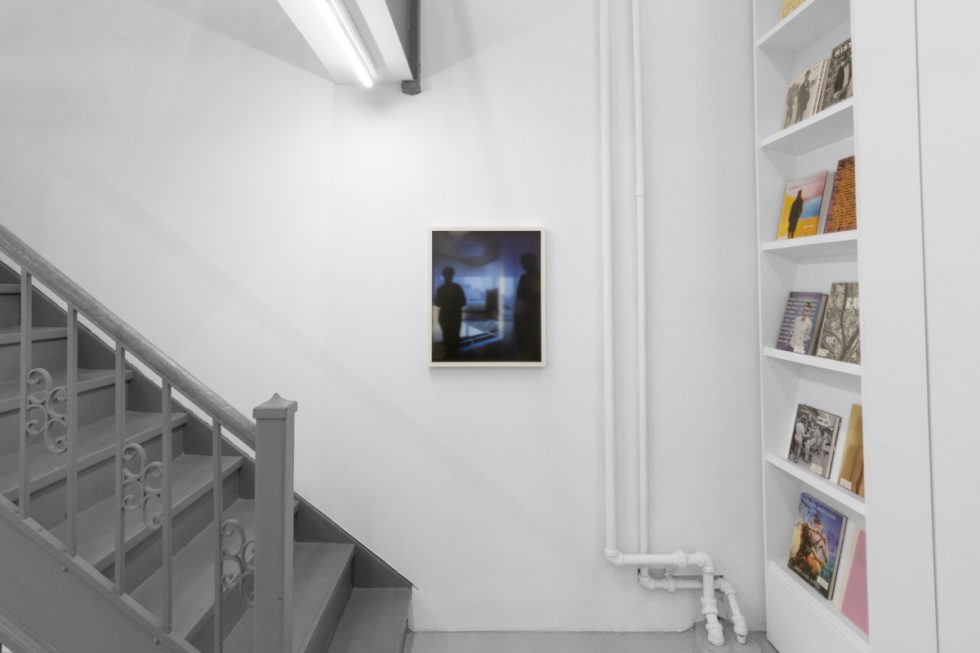 A photograph of an installation of colorful abstract works on a white gallery wall.