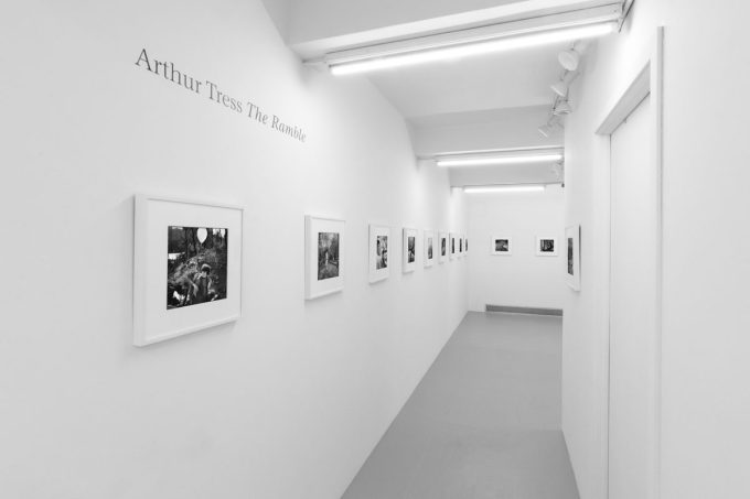 A photograph of black and white photographs in simple white frames on white gallery walls.