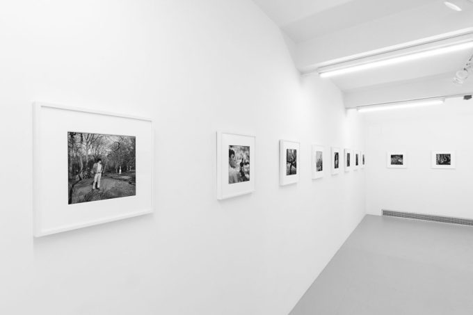 A photograph of black and white photographs in simple white frames on white gallery walls.