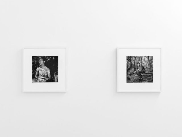A photograph of black and white photographs in simple white frames on white gallery walls.