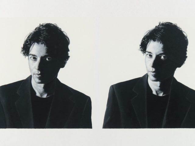 A black and white portrait of two men on a white background.