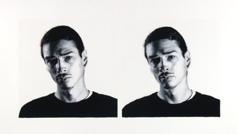 A black and white portrait of two men on a white background.