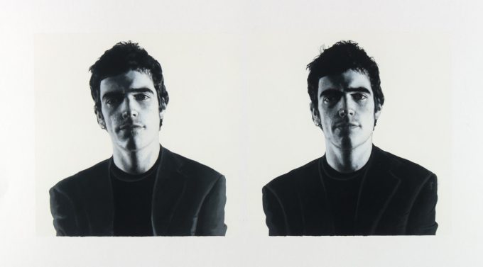 A black and white portrait of two men on a white background.