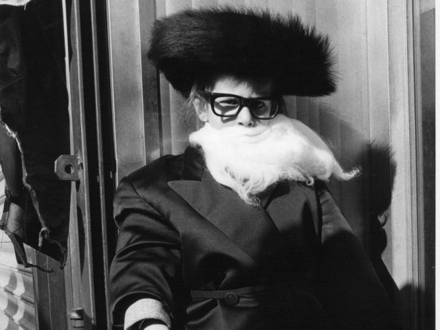 A black and white photograph of a boy dressed up as a rabbi.