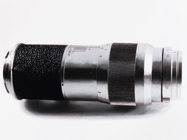 A black and white drawing of a camera lens on a white still life backdrop.