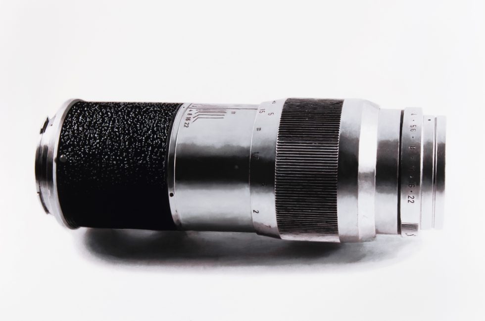 A black and white drawing of a camera lens on a white still life backdrop.