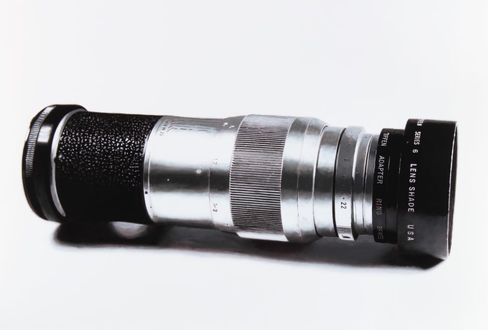 A black and white drawing of a camera lens on a white still life backdrop.