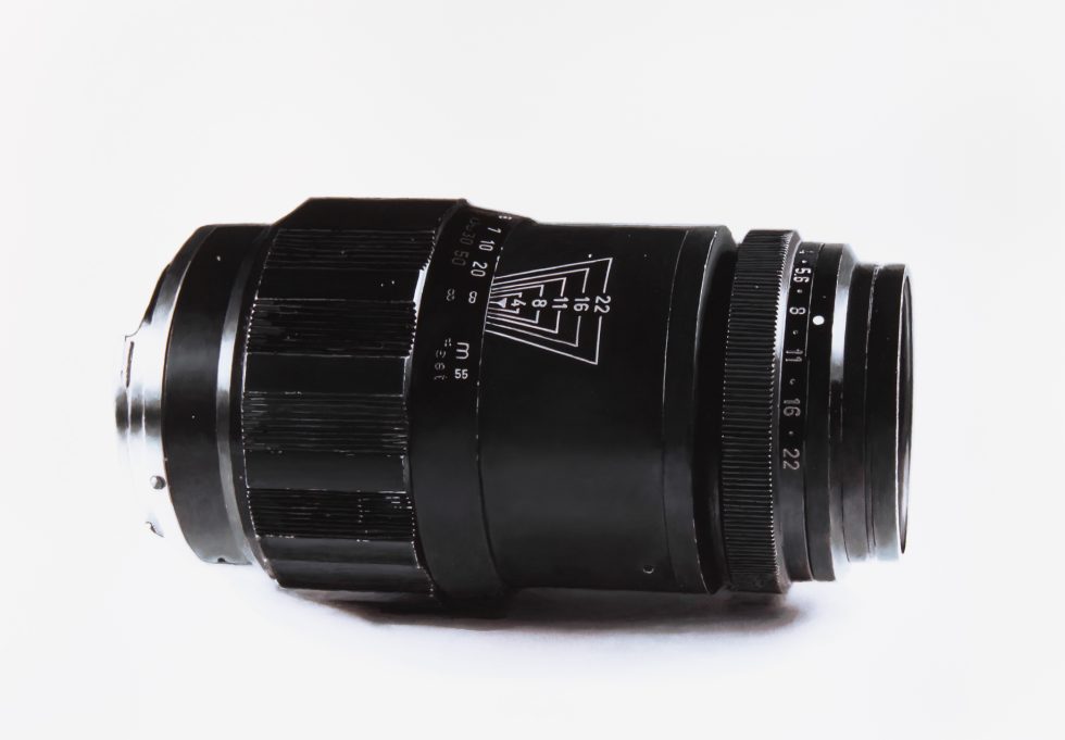 A black and white drawing of a camera lens on a white still life backdrop.