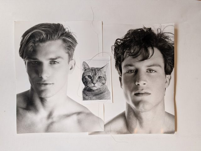 A black and white photograph of two handsome young men with a little kitty.