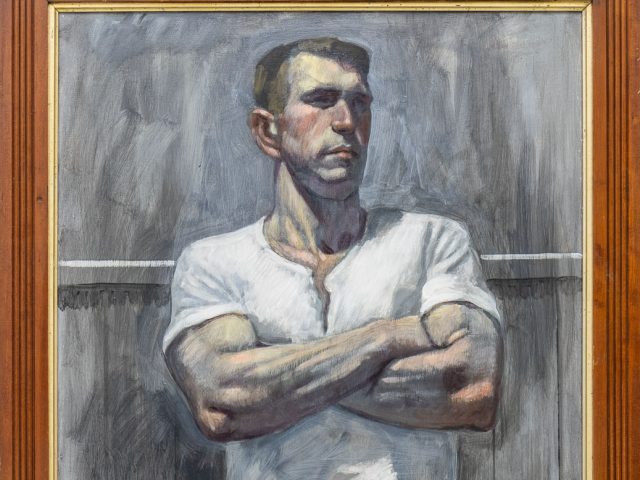 A painting in a brown wood frame of a man in a white tee shirt crossing his arms.