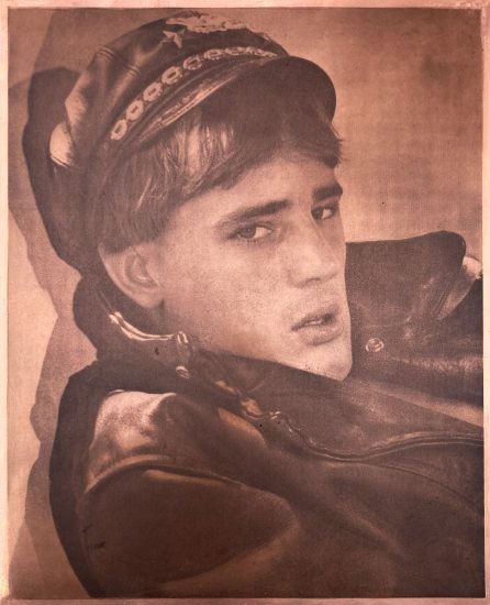 A copper print of a man in a leather jacket with cap.