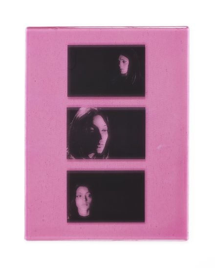 A pink piece of glass with three images on it.