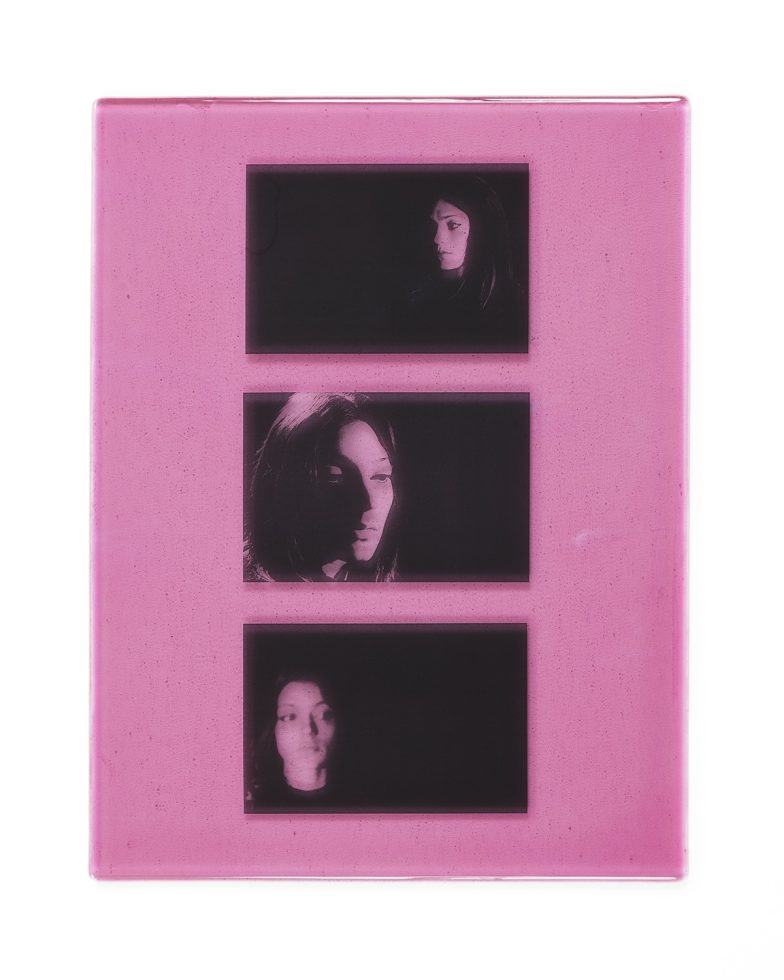 A pink piece of glass with three images on it.