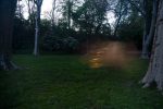A color photograph of a grassy field at night.