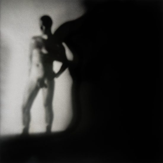 A black and white photograph of a nude man.