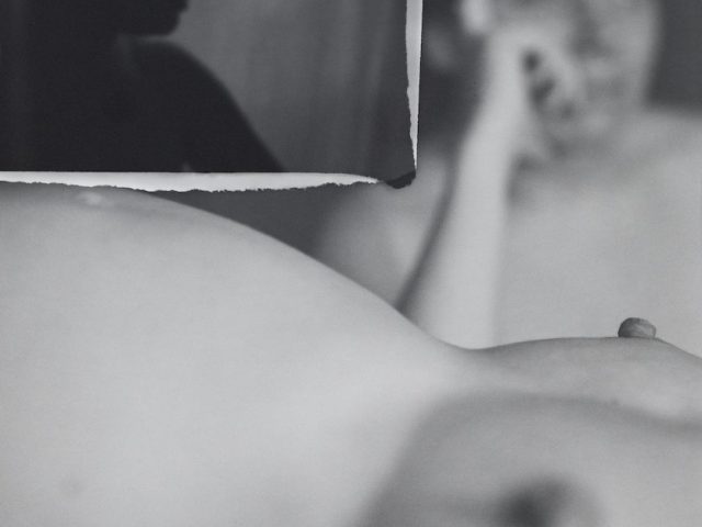 A black and white image of a nude figure.