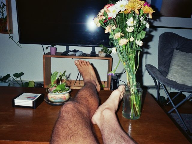 A photograph of two legs on a coffee table.