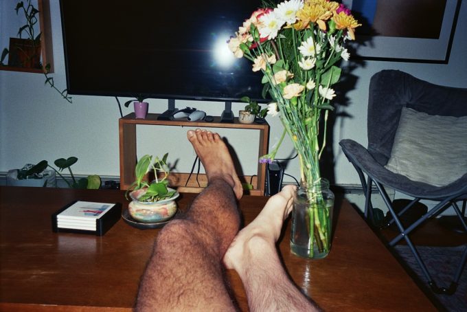 A photograph of two legs on a coffee table.