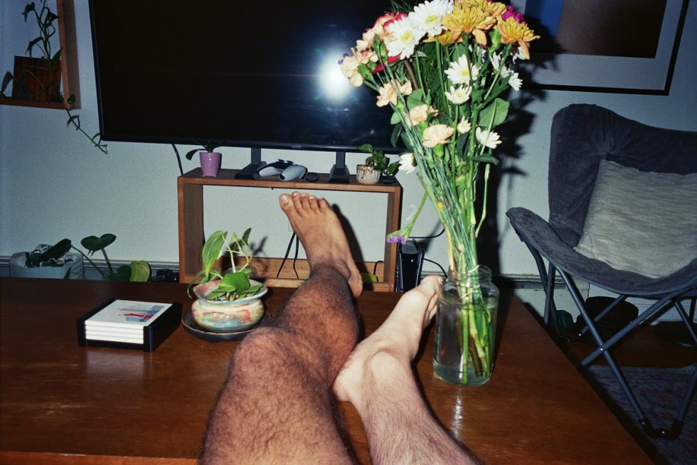 A photograph of two legs on a coffee table.