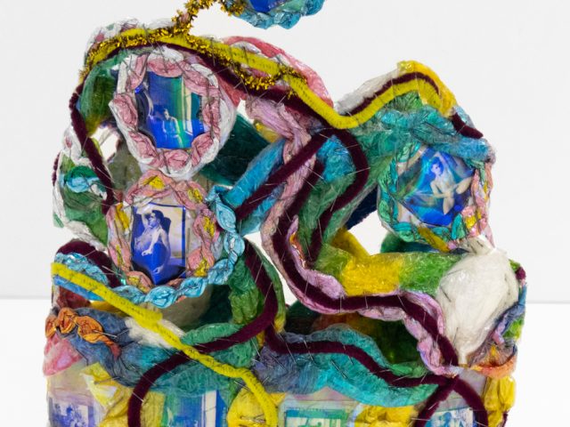 A brightly colored sculpture depicting a crown.