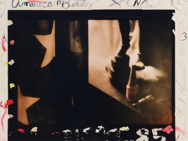 A photograph showing an american flag, sculpture, and various markings in the margins.