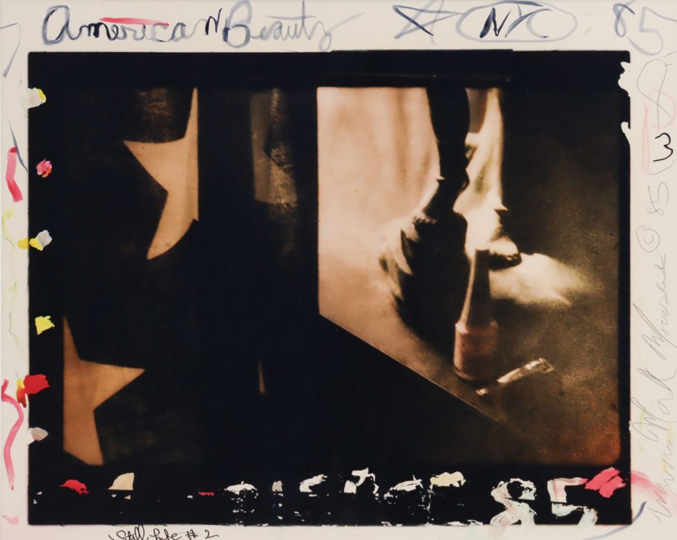 A photograph showing an american flag, sculpture, and various markings in the margins.