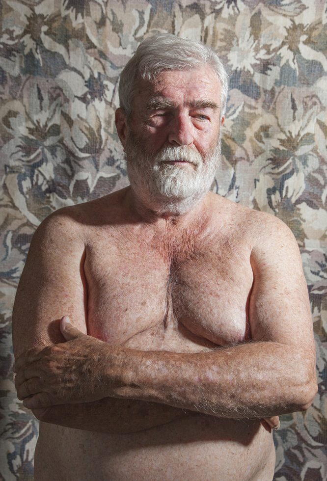 A color photograph of a shirtless older man with a white beard.