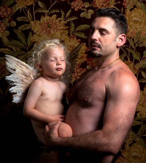 A color photograph of a man holding a young child.