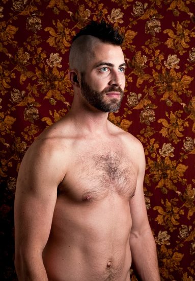 A color photograph of a shirtless man.