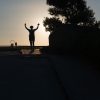 This is a color photograph of someone running towards the sunset.