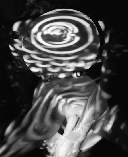This image shows the body of a naked man from the waist down. A spiral of light covers the upper half of his chest.