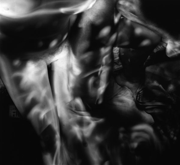 This image shows the ghostly, blurred figure of a naked man in the interior of an apartment.