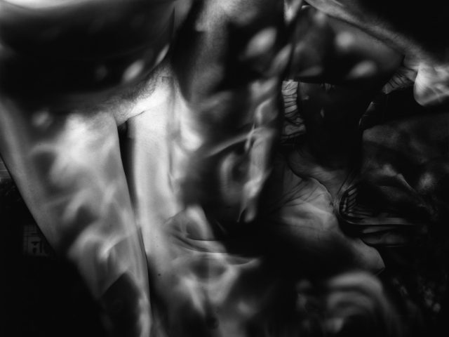 This image shows the ghostly, blurred figure of a naked man in the interior of an apartment.