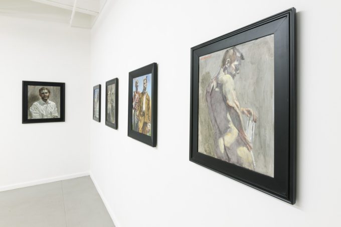 This photograph shows the walls of a gallery where five framed paintings hang. They depict men performing various activities.