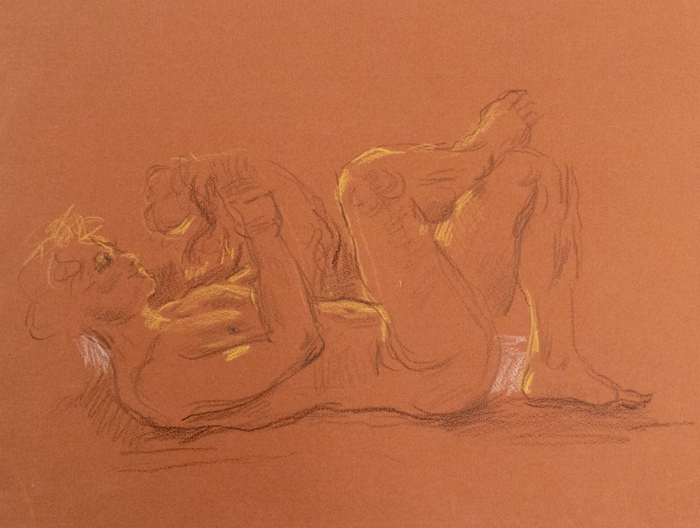 This is a sketch on orange paper of a man laying on his back and holding an animal up to his face.