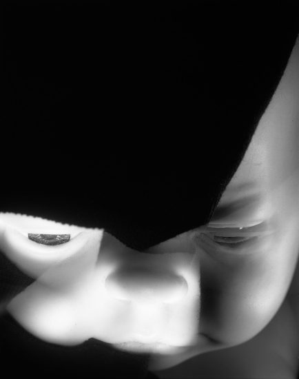 This black and white photograph shows the ghostly face of a baby. It's zoomed in on the baby's facial features, including its lips, nose, and eyes.