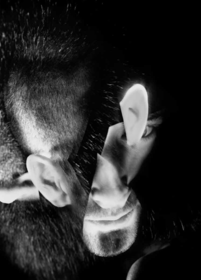 This black and white photograph shows the head of a man, fragmented into pieces that overlap so his ears appear to come out of the very top and lower half of his head.