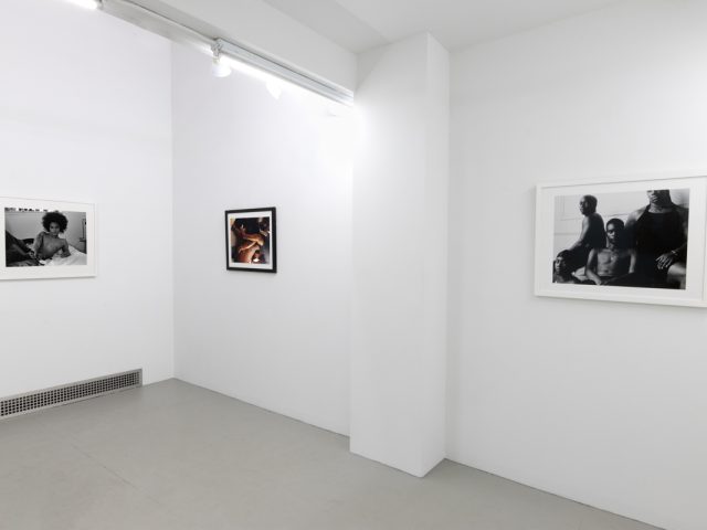 This photograph depicts the walls of a gallery. Three photographs are sequenced there, all by the artist Lindsay Perryman.