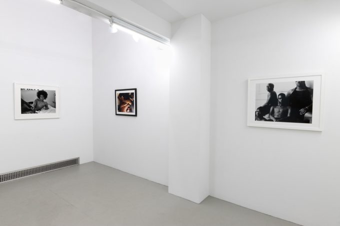 This photograph depicts the walls of a gallery. Three photographs are sequenced there, all by the artist Lindsay Perryman.