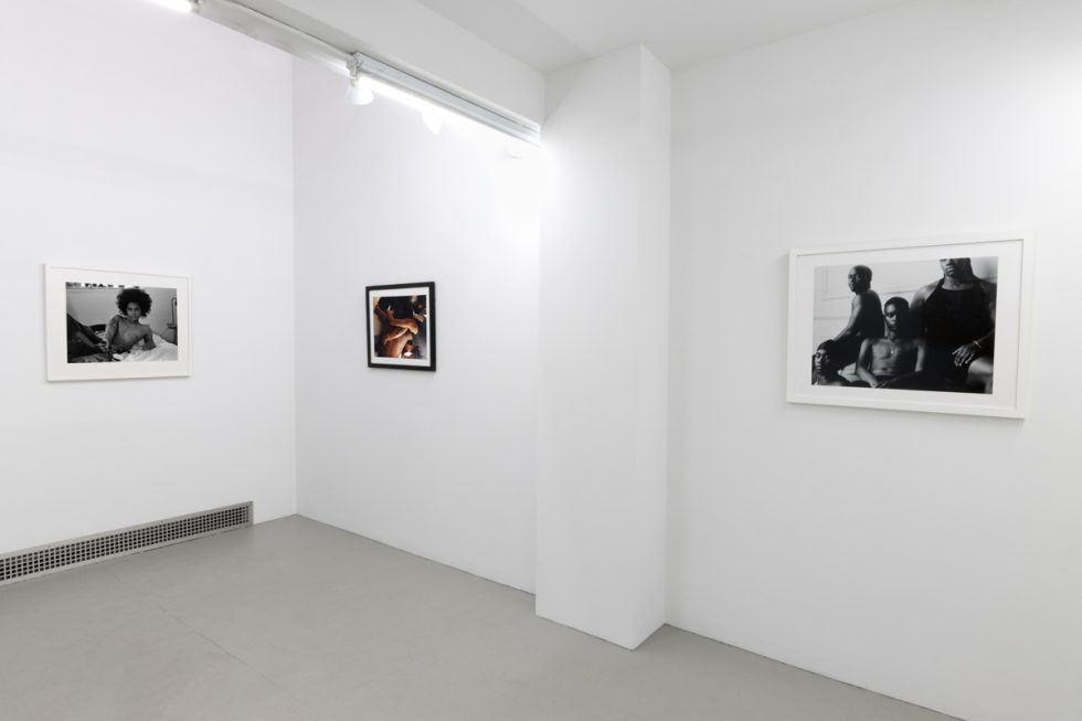 This photograph depicts the walls of a gallery. Three photographs are sequenced there, all by the artist Lindsay Perryman.