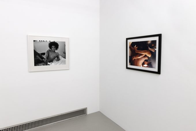 This photograph shows the walls of a gallery with two photographs by Lindsay Perryman.