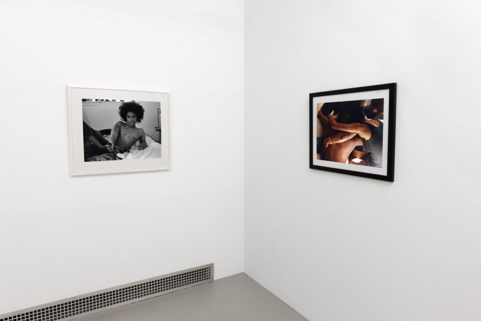 This photograph shows the walls of a gallery with two photographs by Lindsay Perryman.