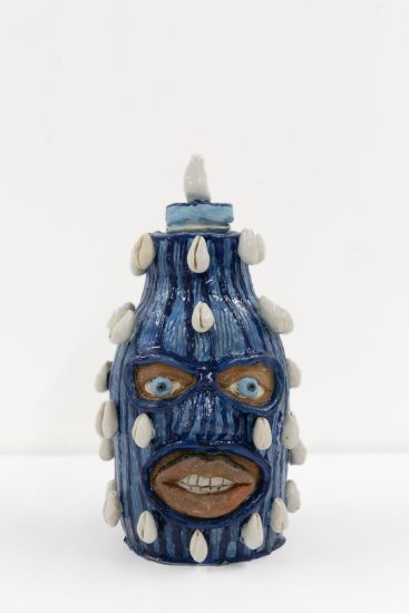 A ceramic vessel depicting a head wearing a balaclava.