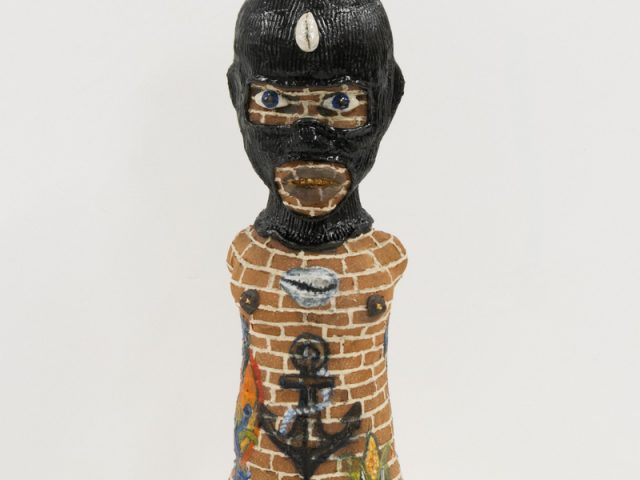A ceramic vessel depicting a human figure with skin resembling bricks.