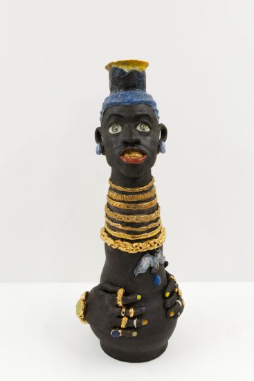 A ceramic vessel depicting a figure with gold necklaces, rings, and a watch.