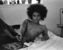 A black-and-white photograph of a person reclining without a shirt.