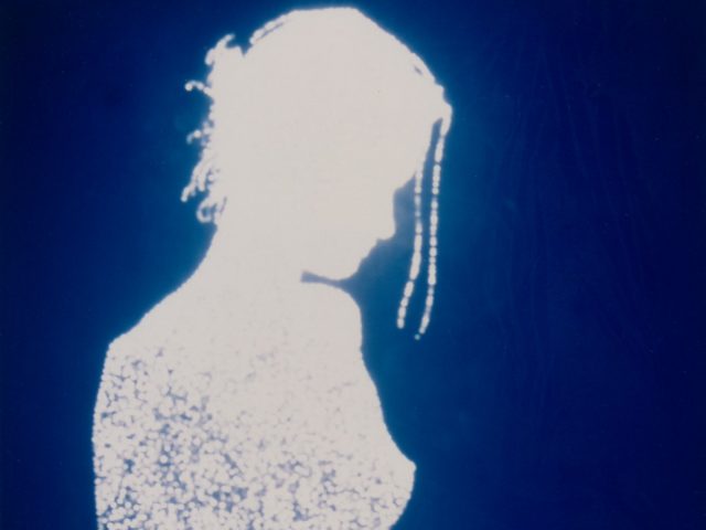 This is a silhouette of a girl over a blue background, resembling a cyanotype.
