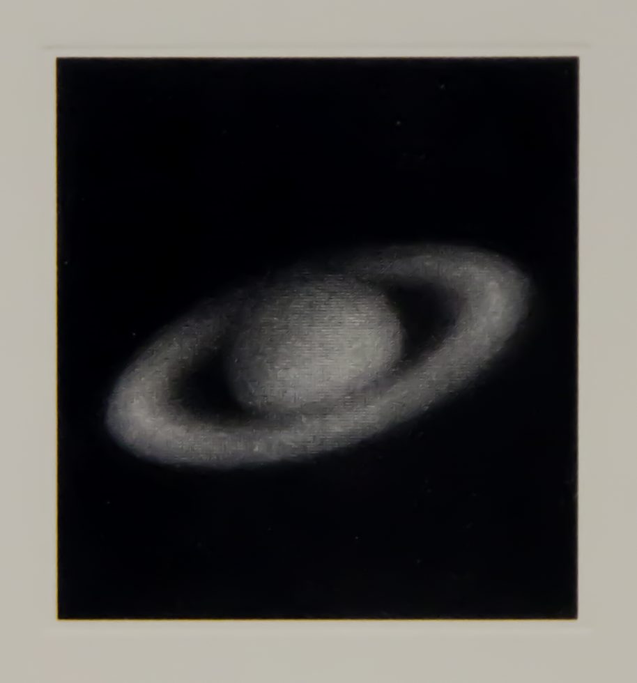 This is a lithograph of Saturn in black & white on woven paper.