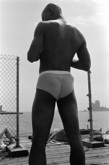 This black and white photograph shows a man's back, facing away from the camera.