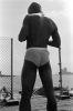 This black and white photograph shows a man's back, facing away from the camera.